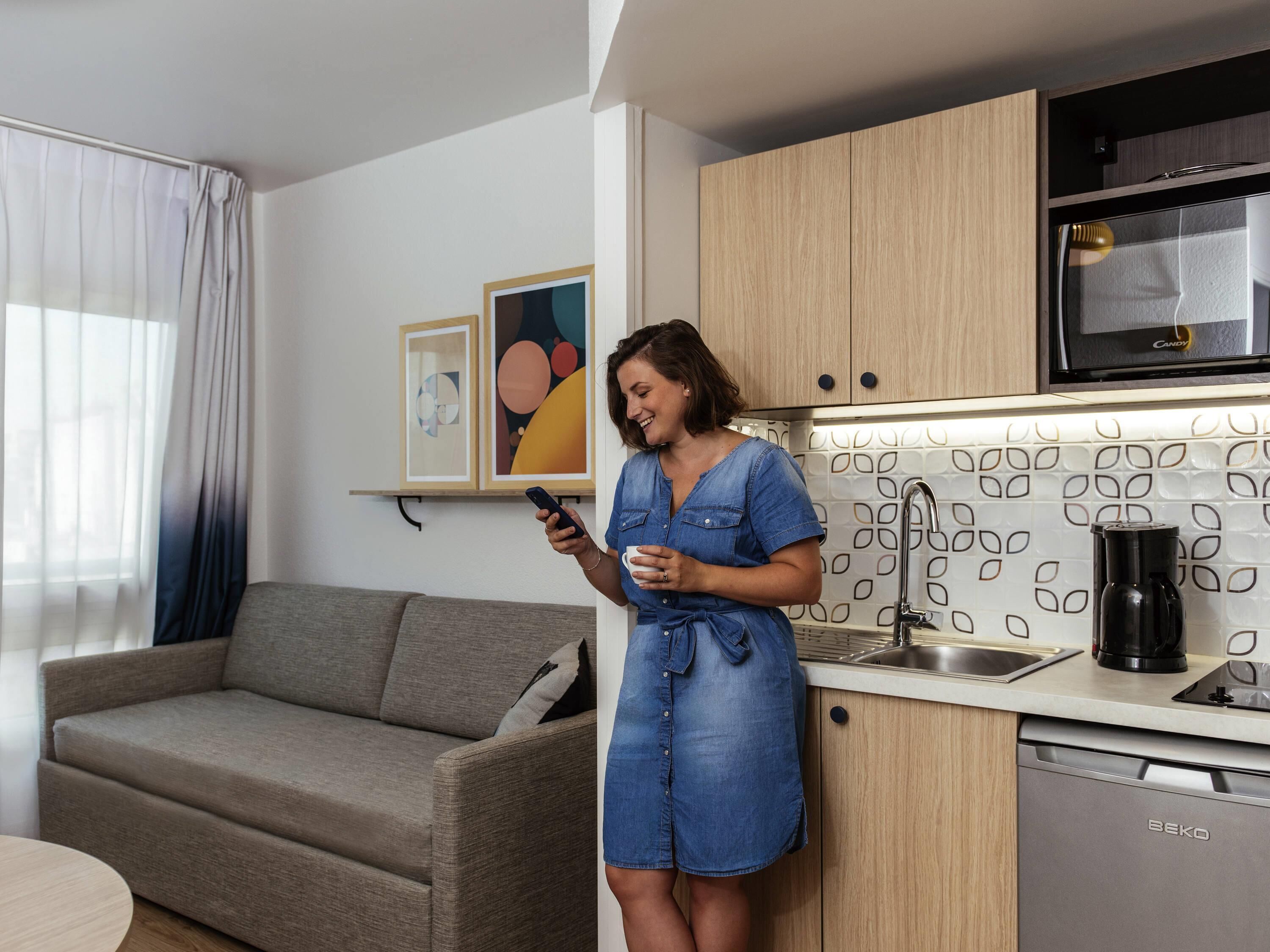 A modern kitchen with wooden cabinets, a built-in microwave, and a coffee maker.