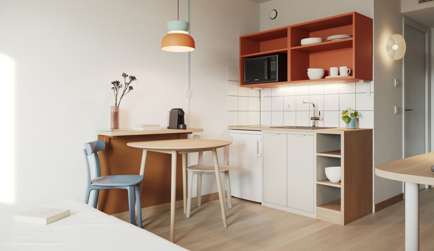 A compact kitchen with a microwave, a sink, and a dining area with chairs.