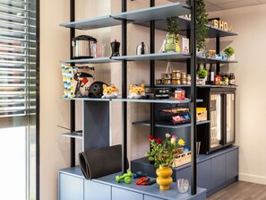 A modern kitchen with a built-in refrigerator, shelves with kitchenware, and a small plant. - Aparthotel Adagio Access Toulouse Jolimont (Toulouse)