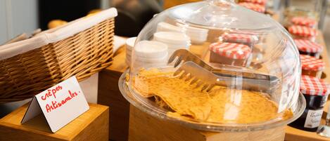 A breakfast buffet with a sign indicating 'crepes artisanals'.
