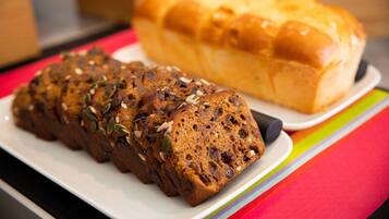 A loaf of bread on a plate with a colorful striped tablecloth.