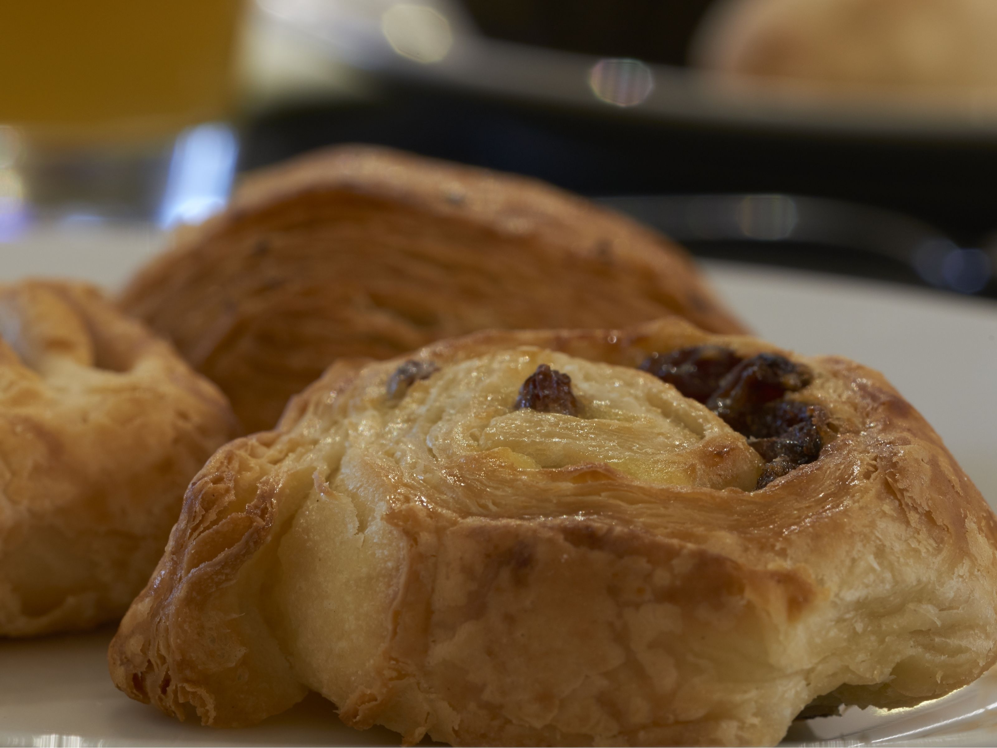 En tallrik med tre bakverk, troligen croissanter, med synlig fyllning.