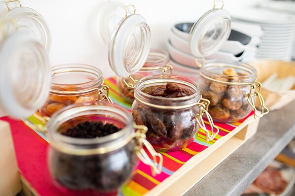 A buffet table with open glass jars containing various food items.