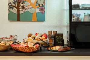 Un buffet de petit-déjeuner proposant une variété de fruits, de pains et de viennoiseries.
