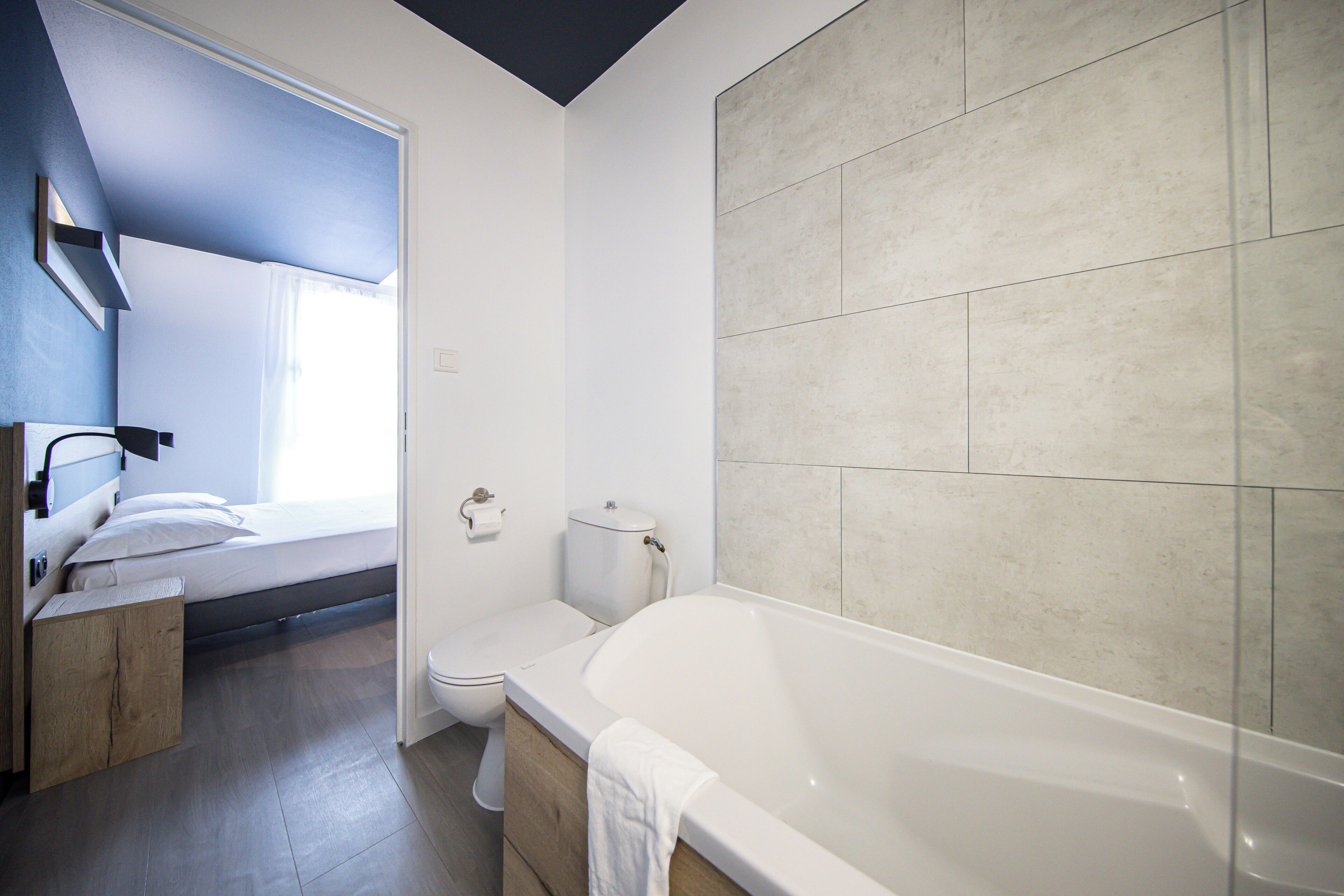 Un baño moderno con bañera, inodoro y zona de ducha.