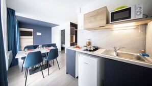 A modern kitchen with a built-in microwave, a sink, and a compact refrigerator. - City Residence Nancy (Nancy)