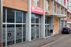 A building with a prominent 'APPART' sign, large windows, and a parked car. - Appart'city Classic Lyon Part Dieu Villette (Lyon)