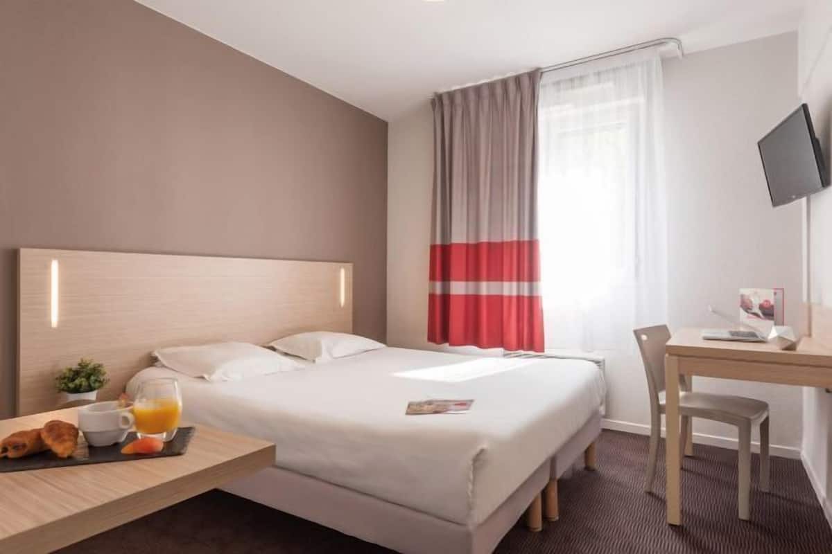 Biancheria da letto di alta qualità, una scrivania, tende oscuranti