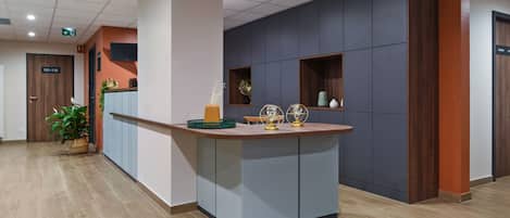 A reception area with a reception desk, potted plants, and decorative items.