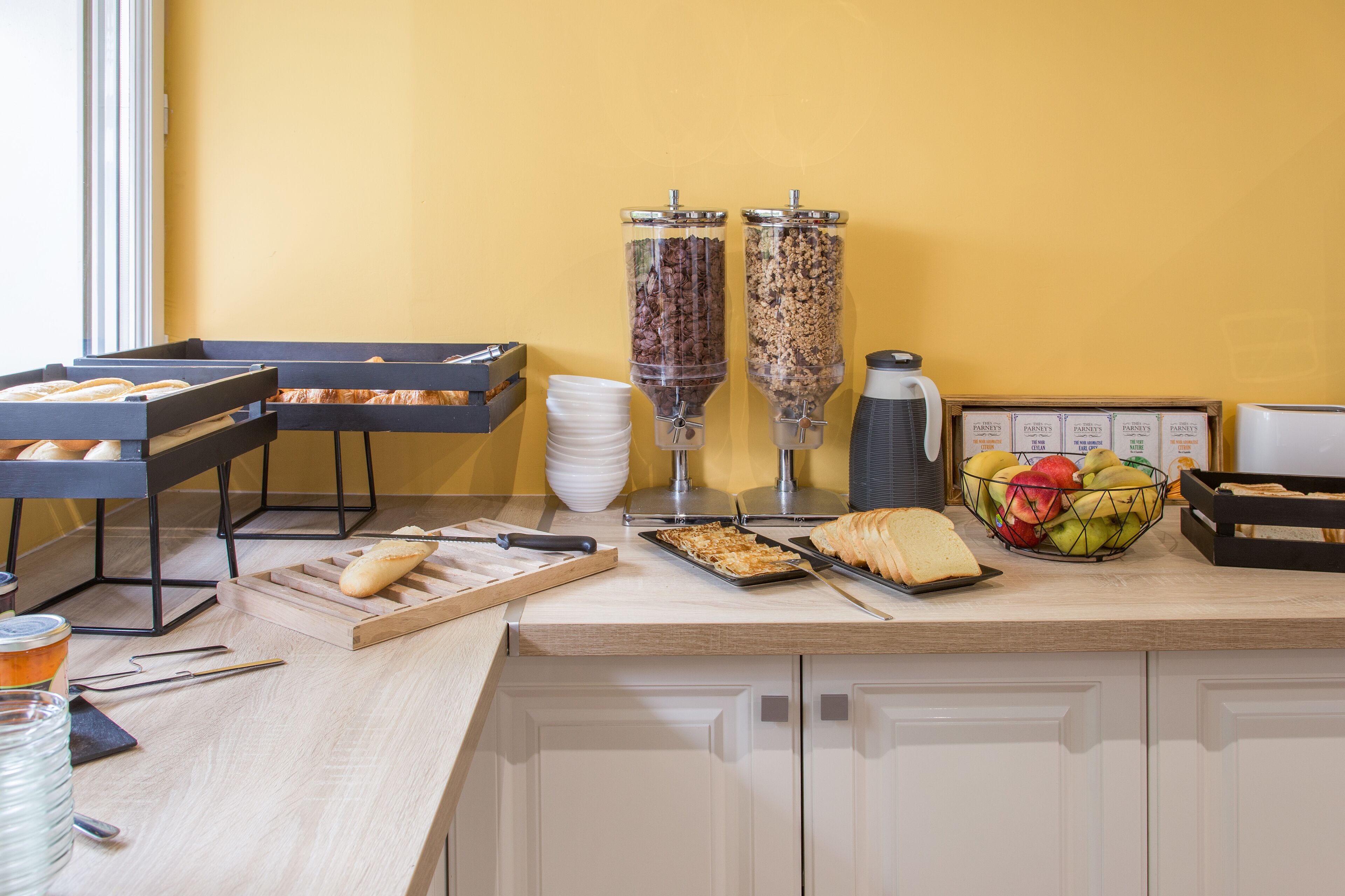 A breakfast buffet setup with various food items and condiments.