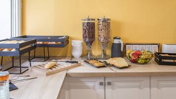 A breakfast buffet setup with various food items and condiments.