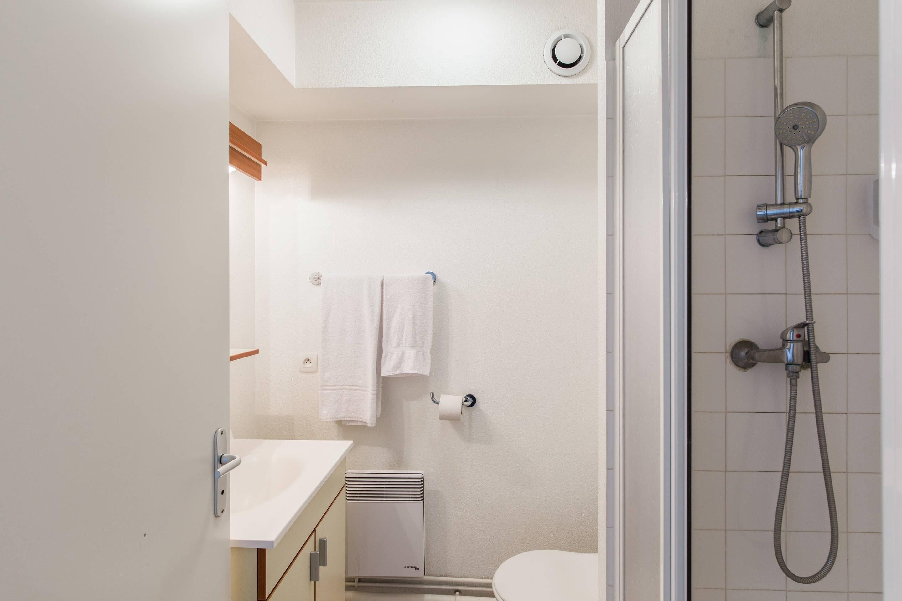 A modern bathroom with a shower, toilet, and sink.