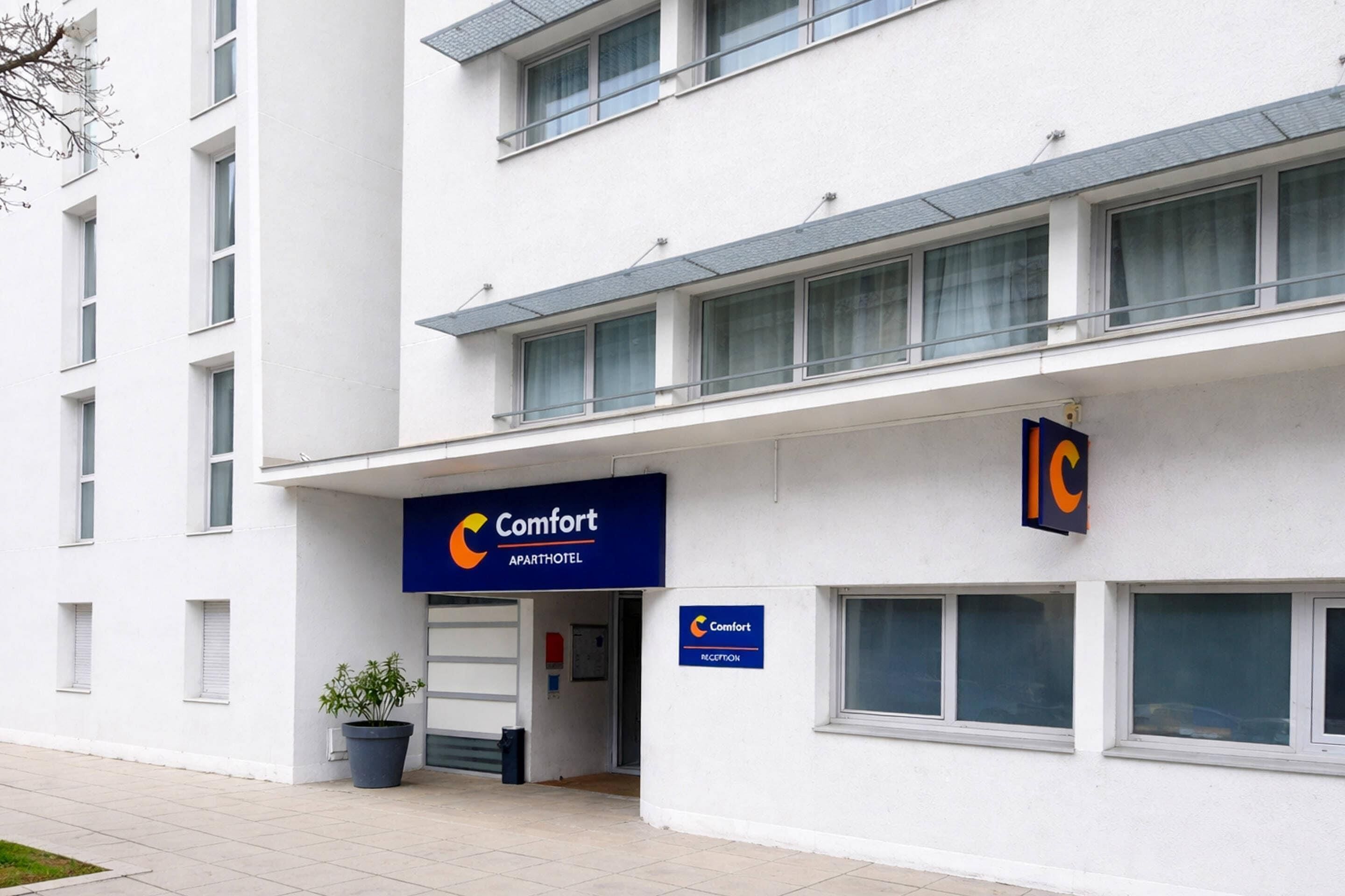 A modern building with a sign for 'Comfort Apartments' and a reception area.