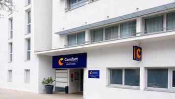 A modern building with a sign for 'Comfort Apartments' and a reception area.