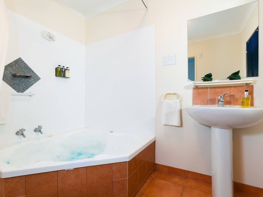 Une salle de bain avec une baignoire, un lavabo et un miroir.