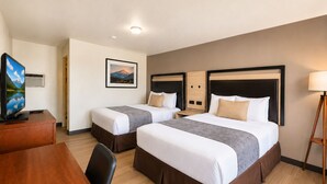 A hotel room with two beds, a desk, a television, and a picture of a mountain. - Heber Inn  (Heber City)