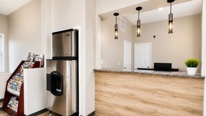 A modern kitchen with a stainless steel refrigerator, wooden flooring, a marble countertop, and pendant lighting. - Heber Inn  (Heber City)