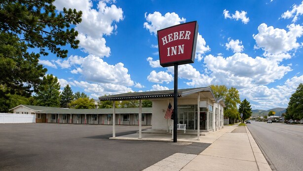 A motel named 'HEBER INN' with a covered parking area and a row of single-story buildings. - Heber Inn  (Heber City)