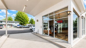 A gas station with a clear 'OPEN' sign, a covered parking area, and a building with large windows. - Heber Inn  (Heber City)