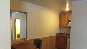 A small kitchen with wooden cabinets, a dining table, and chairs.