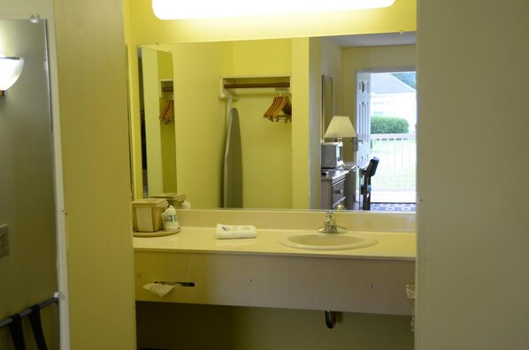 A bathroom with a sink, mirror, towel rack, and a view of the outside. - A Richland Inn Lewisburg (Lewisburg)