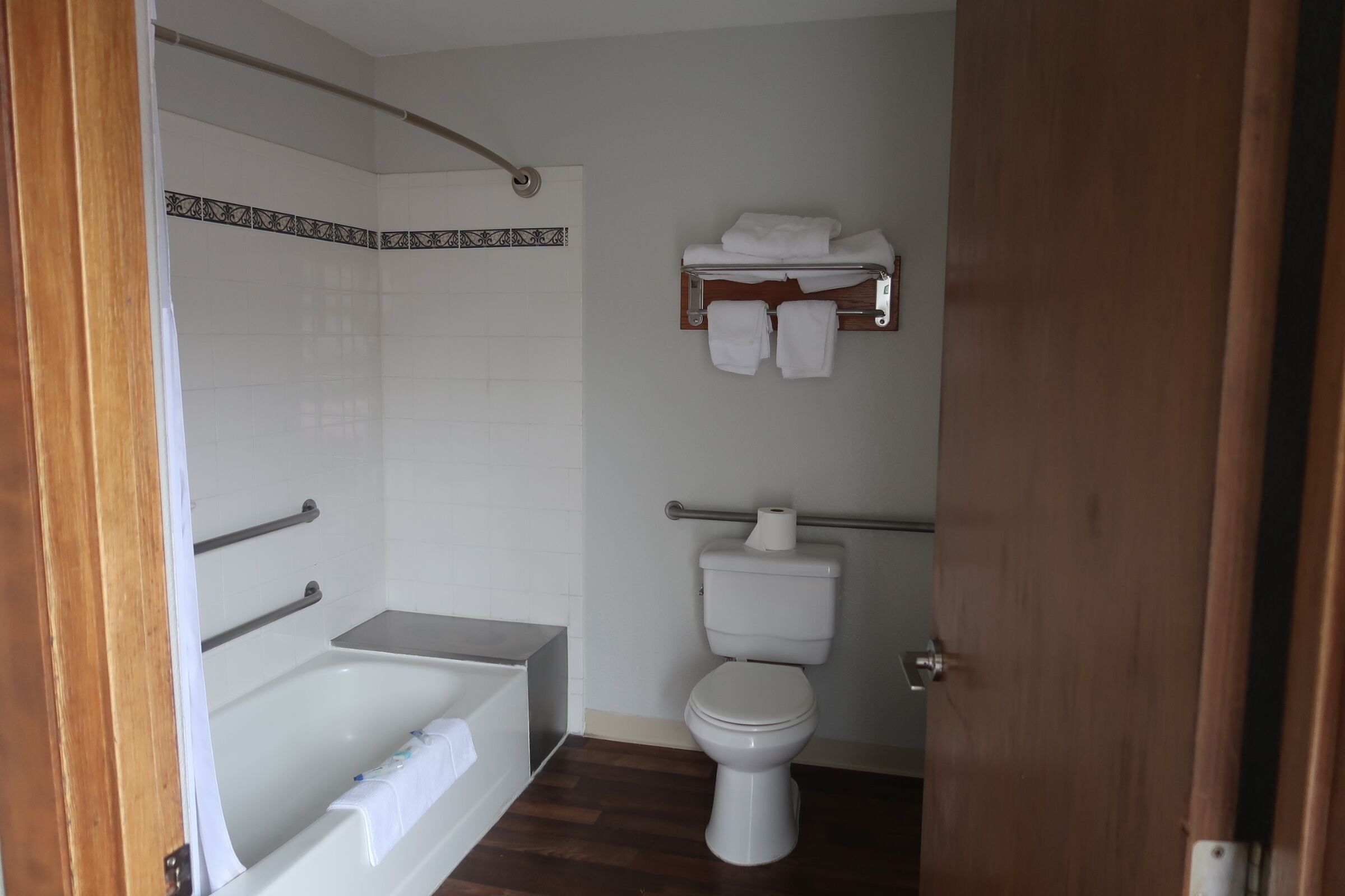 A bathroom with a bathtub, toilet, and towel rack.