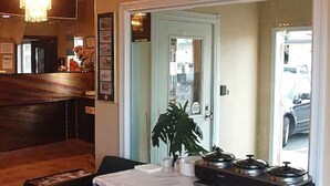 A room with a wooden bench, a table with a lace tablecloth, and a plant. - Merrill Field Inn (Anchorage)