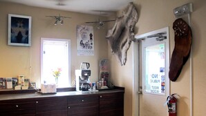 A kitchen with a coffee maker, a clock, and a fire extinguisher. - Merrill Field Inn (Anchorage)