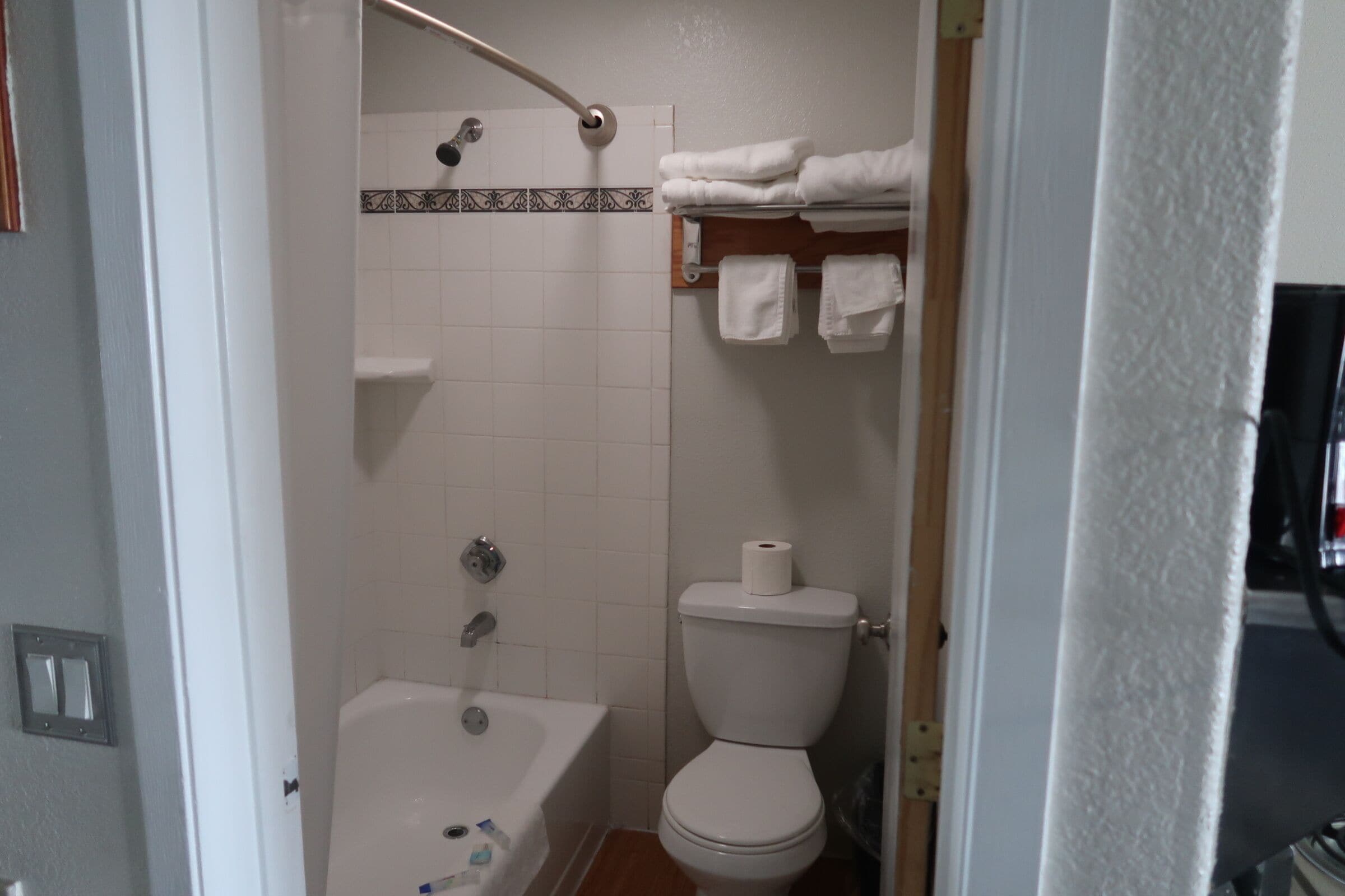 Un baño con bañera, inodoro y barra para toallas.
