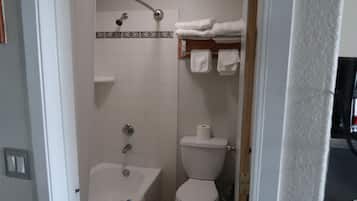 Un baño con bañera, inodoro y barra para toallas.