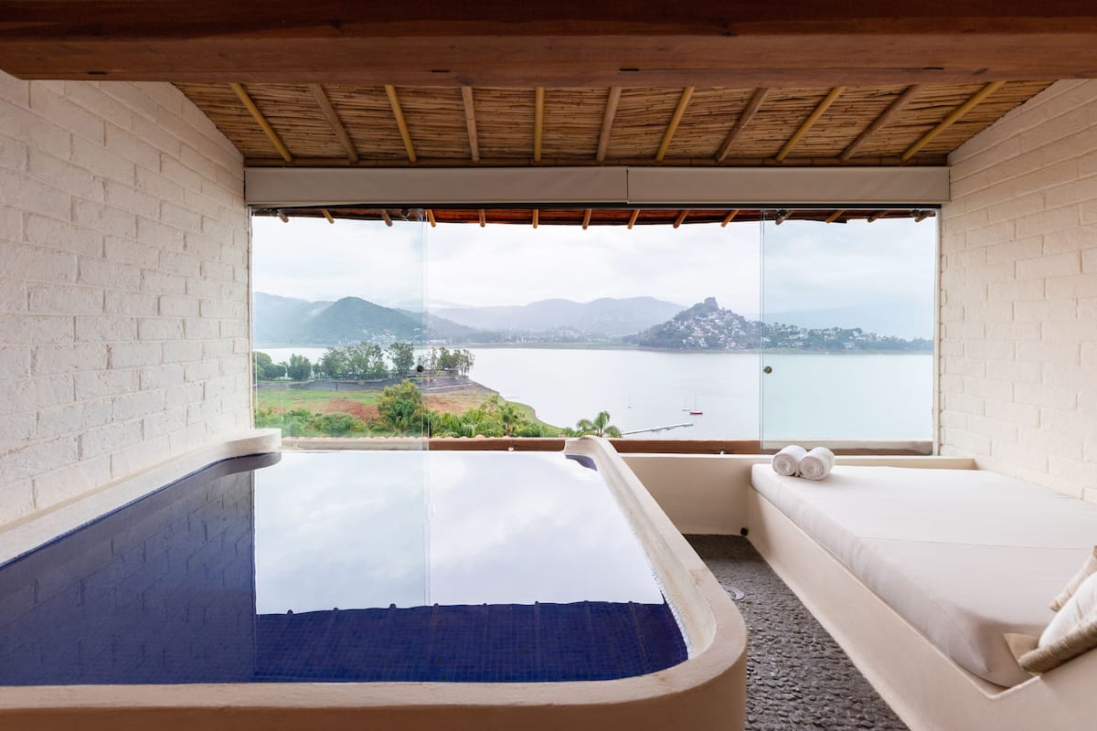 Ein Zimmer mit großem Fenster, einer Badewanne und einer Couch mit Handtüchern.