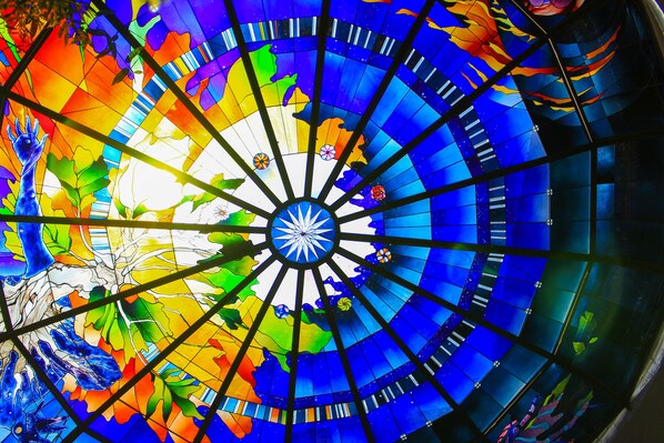 Uma cúpula de vitrais com desenho radial e uma estrela central.