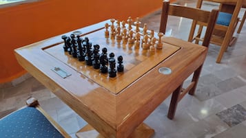 A wooden foosball table with a checkered surface and two sets of black and white foosball figures.
