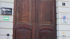 Una puerta doble de madera grande con un cartel que indica que es un hotel.