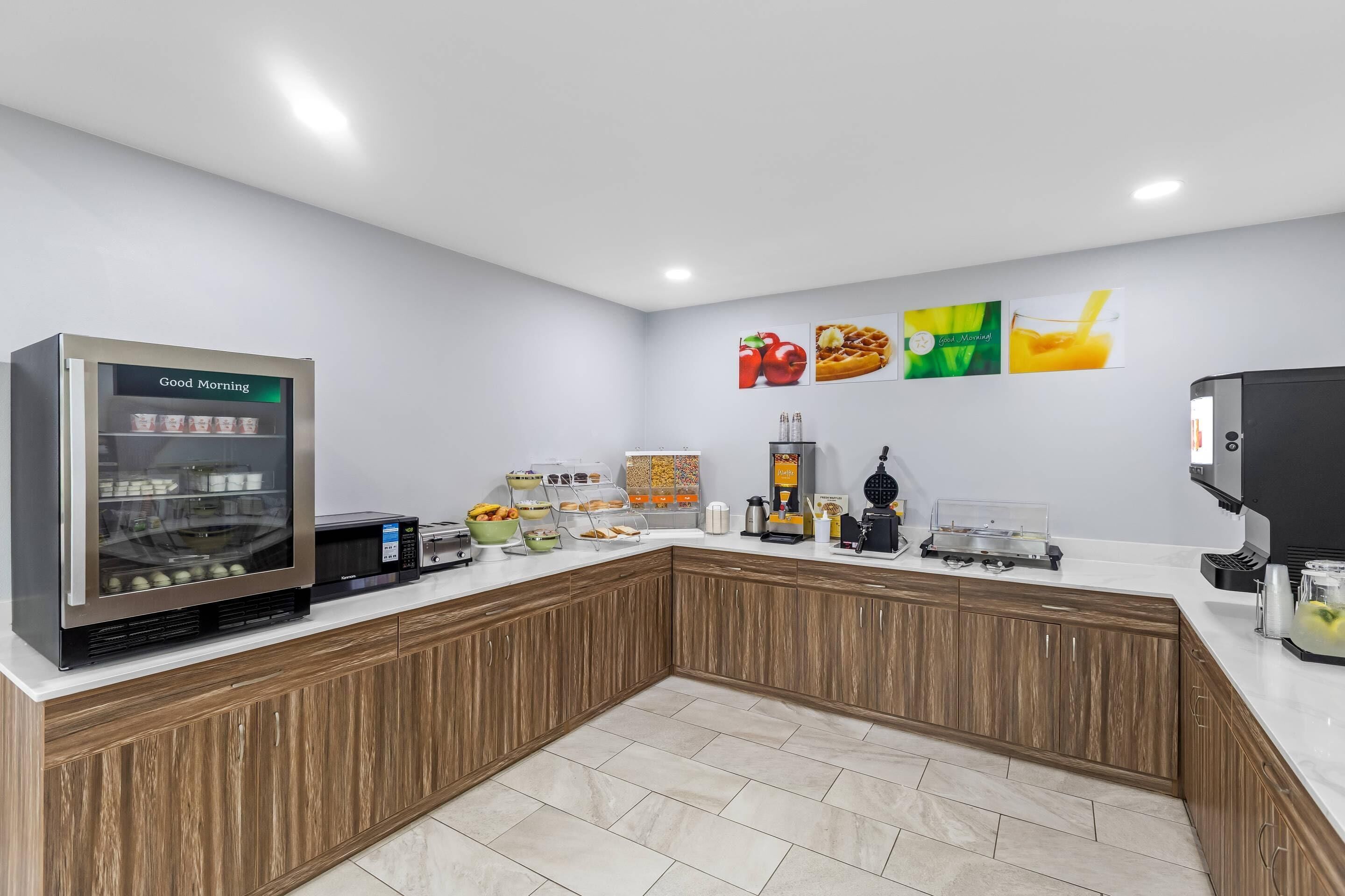 Una cocina moderna con cafetera, refrigerador y microondas.