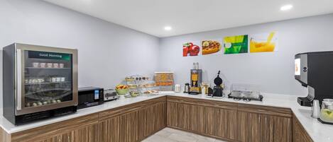 Una cocina moderna con cafetera, refrigerador y microondas.