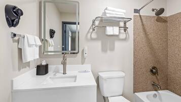 Een moderne badkamer met een wastafel, toilet en bad.