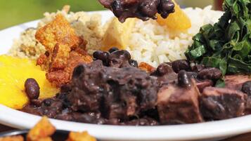 A plate of food with rice, beans, meat, and vegetables.
