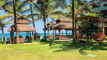 Praia particular, areia branca, barracas de praia de cortesia