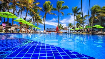 Una piscina al aire libre, camas de piscina gratis, sombrillas