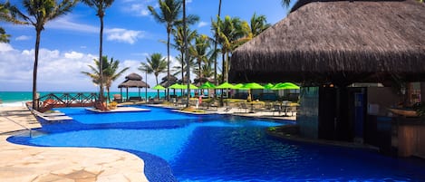 Una piscina al aire libre, camas de piscina gratis, sombrillas