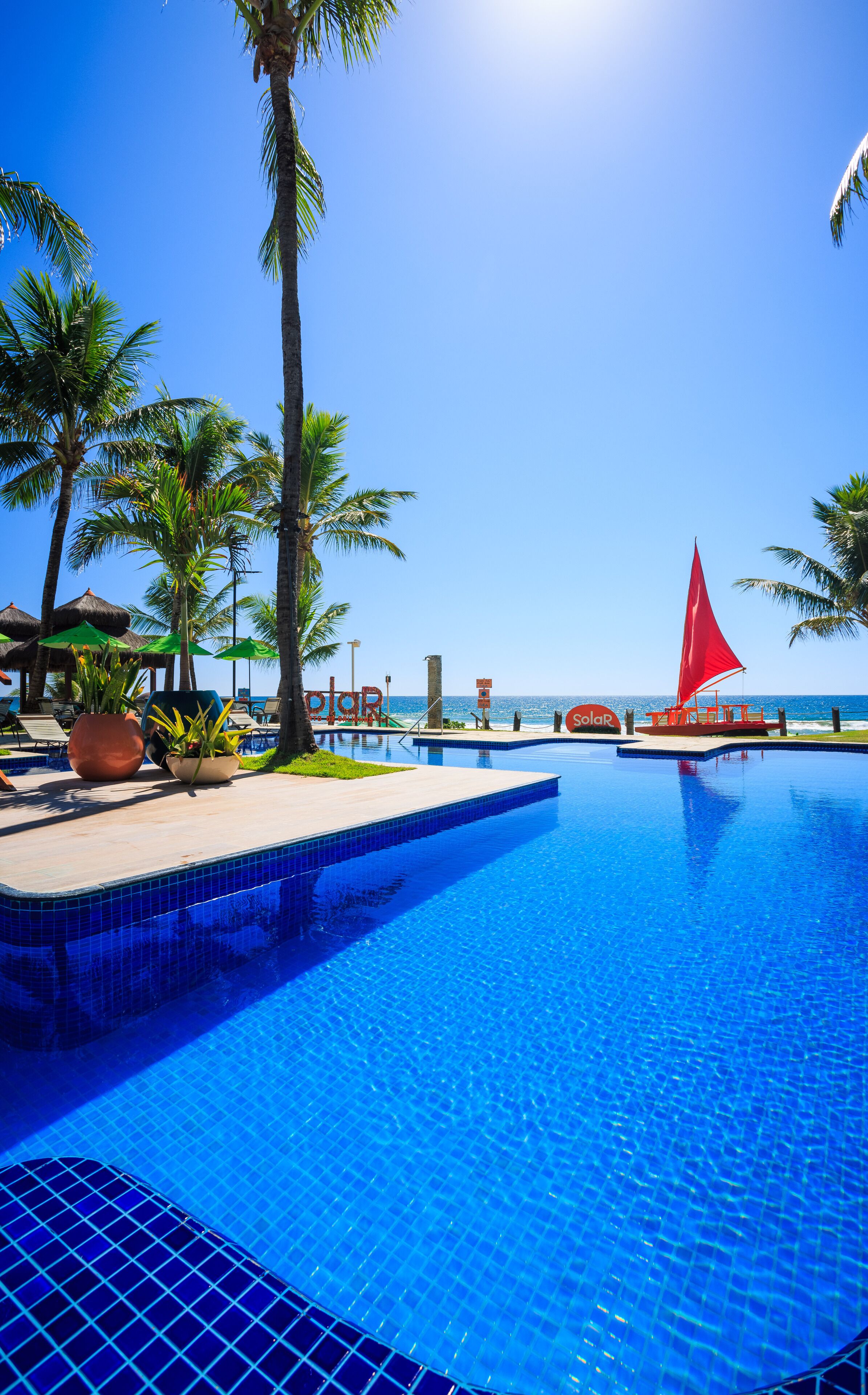 Una piscina al aire libre, camas de piscina gratis, sombrillas