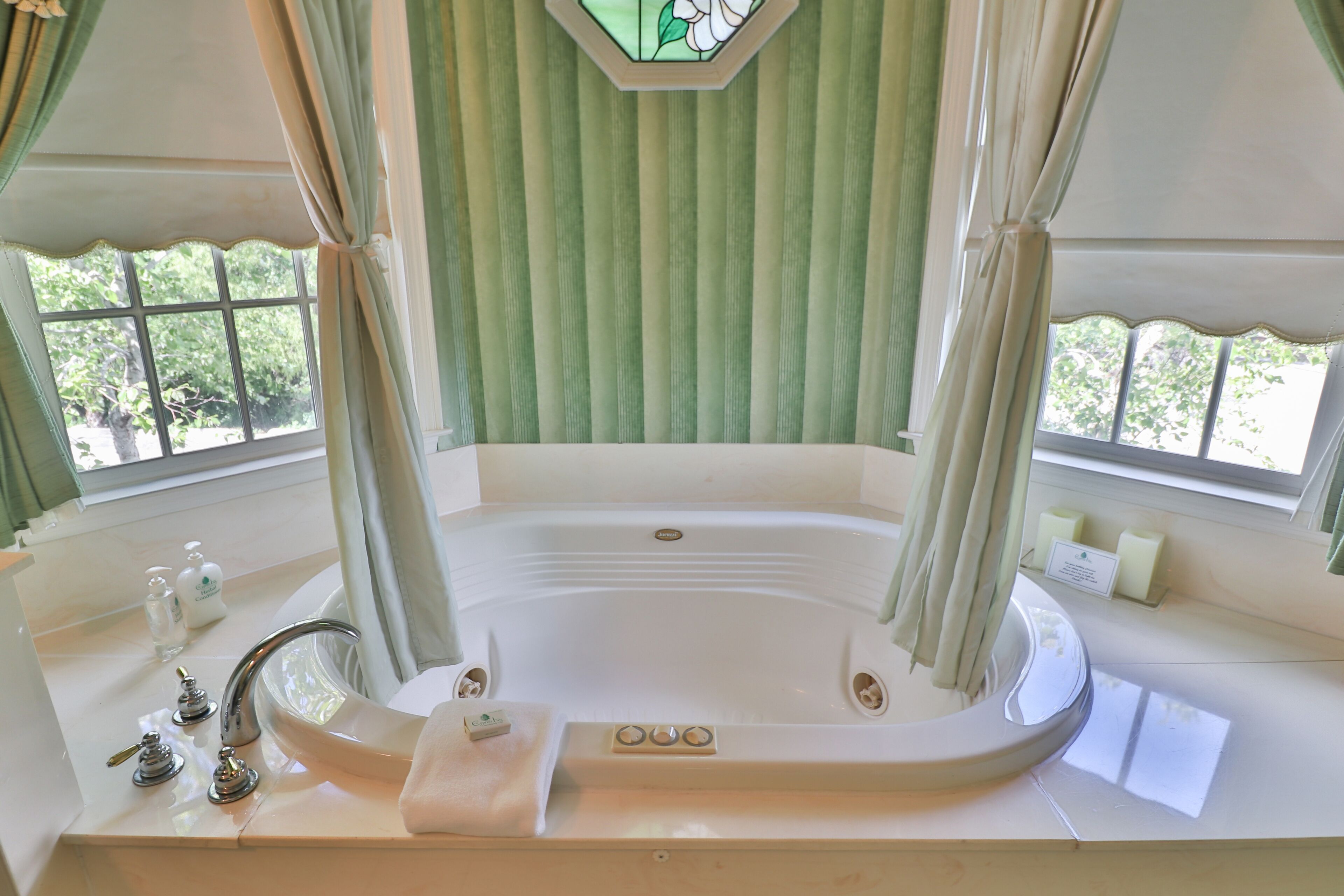 Une salle de spa équipée d’une grande baignoire, d’un lavabo et d’un miroir.