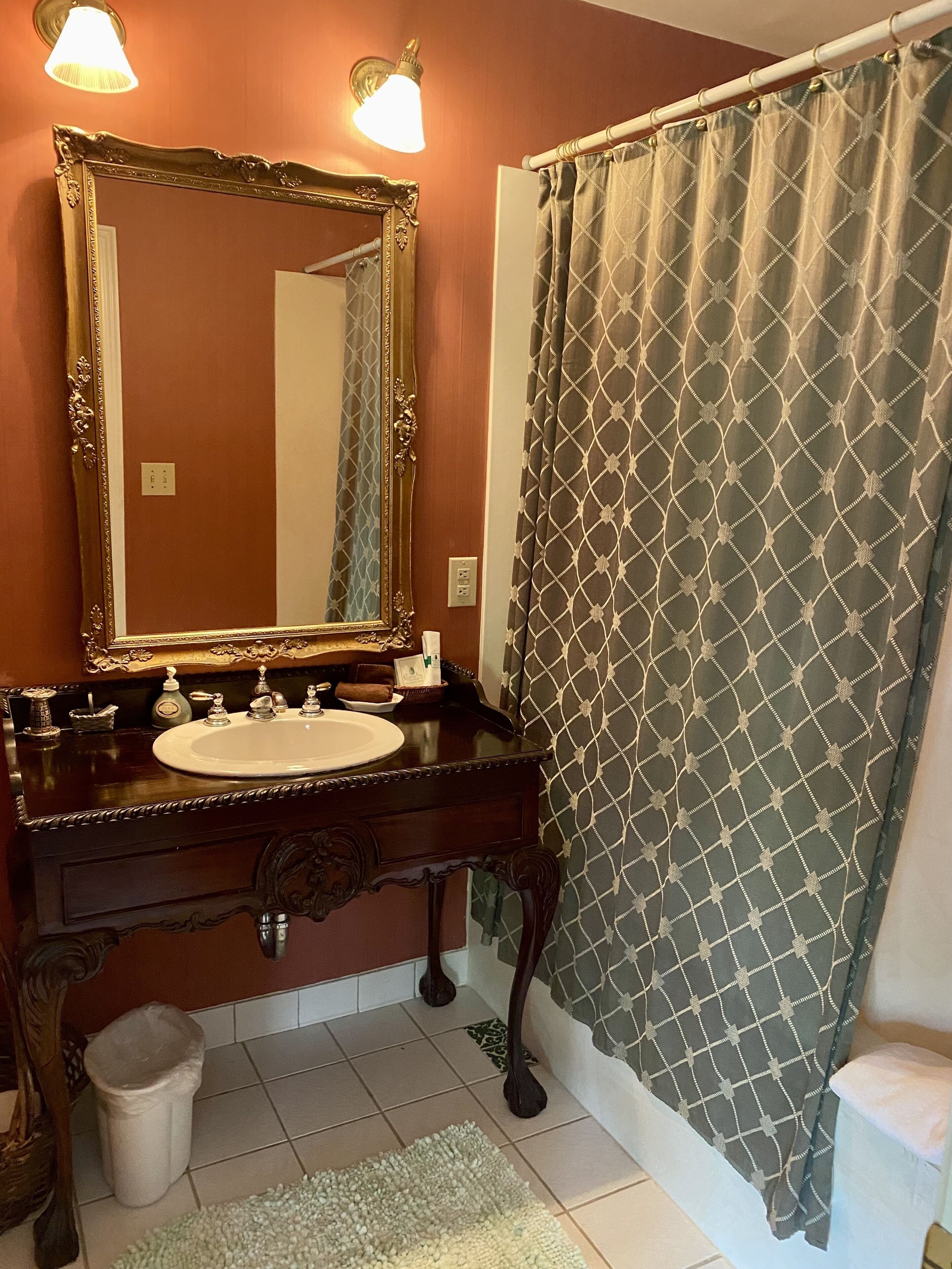 A bathroom with a vanity, sink, mirror, and shower curtain.