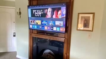 A television mounted on a wooden wall above a fireplace, displaying the 'Final Cut' menu.