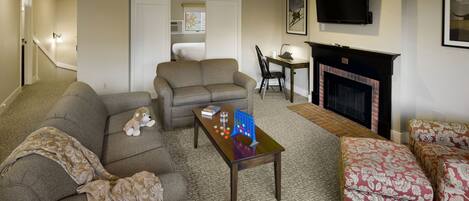 A living room with a sofa, a coffee table, and a fireplace.