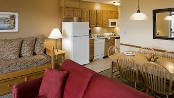A compact living space with a kitchenette, a dining area, and a sofa.