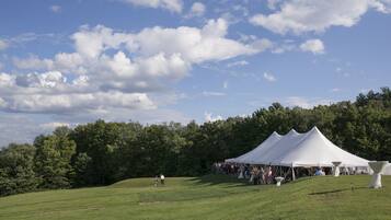Guests can enjoy a serene outdoor setting with a large grassy field and wooded area.