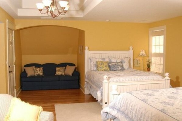 A bedroom with a bed, a sofa, and a chandelier. - Timber Creek Bed & Breakfast (Paxton)
