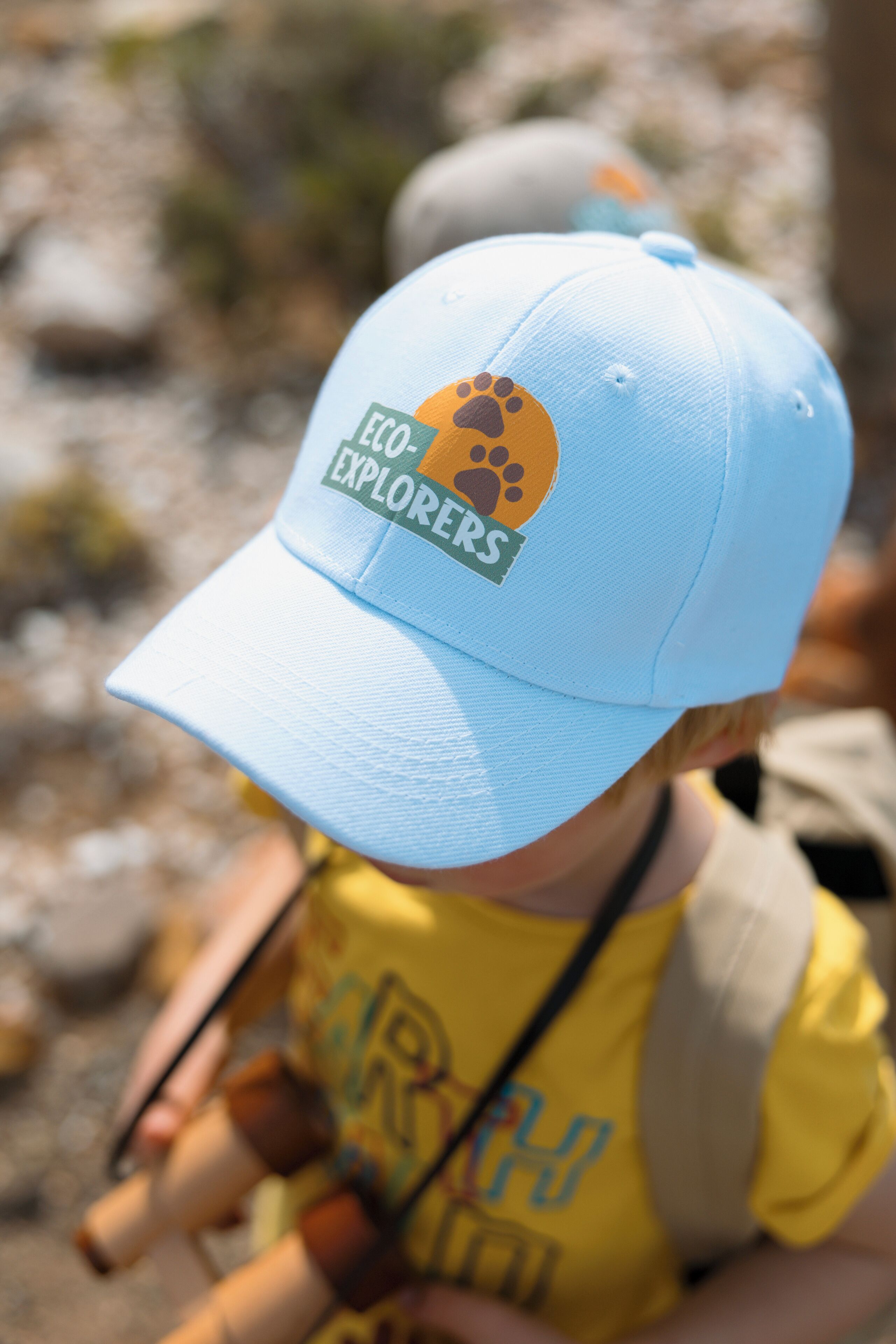 Gros plan d’une casquette bleu clair ornée d’une empreinte de patte et du texte « ECO EXPLORERS ».